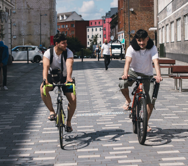 Two men on bicycles, pedaling along a scenic route, highlighting an active lifestyle and friendship.